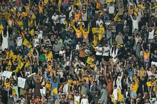 Spectators cheer from the stands during the Pakistan Super League (PSL) Twenty20 final match between Hyderabad Kingsmen and Peshawar Zalmi at the Gaddafi Stadium in Lahore on May 3, 2026. (Photo by Arif ALI / AFP)