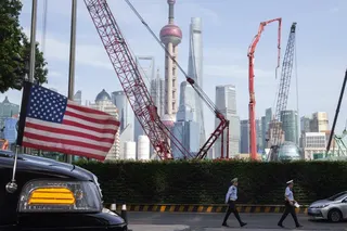 Chinese traffic police officers walk by a US flag on an embassy car outside a hotel in Shanghai on July 30, 2019, as officials from both sides met for talks aimed at ending a tariff war. Photo: AP