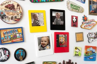 Four VidaBay Snap magnetic photo frames attached to a white board surrounded by magnets.