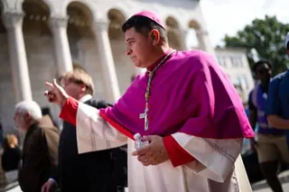 A man in religious vestments walks outside