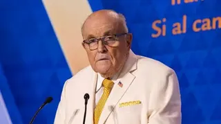 Rudy Giuliani wearing a white suit.