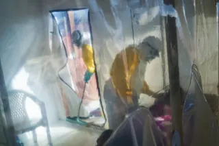 Health workers in protective suits in an isolation unit