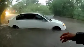 White sedan stuck in floodwaters