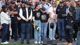 Richard Childress, Samantha Busch, Brexton Busch, and Steve O’Donnell standing on NASCAR grid