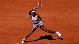 US Coco Gauff hitting a forehand return to US Taylor Townsend on a tennis court.