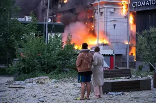 People watch as building burns after a Russian missile attack in Kyiv, Ukraine, Sunday, May 24, 2026. (AP Photo/Efrem Lukatsky)