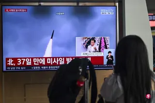 韩国民众星期二在首尔一个火车站观看电视屏幕上播放朝鲜导弹试验新闻报道的档案画面。 （法新社）