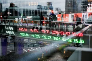 An electronic board shows stock prices below a pedestrian bridge in the Lujiazui financial district in Shanghai. Photo: Reuters