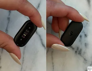 2 side by side images of fingers pinching an ovalshaped black sensor showing the front and back
