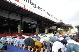 馬來西亞吉隆坡近郊士拉央市場，來自孟加拉與羅興亞移工聚集街角空地，這群穆斯林席地祈禱誦經，氣氛莊嚴平靜，共同迎接哈芝節。中央社記者黃自強吉隆坡攝　115年5月27日