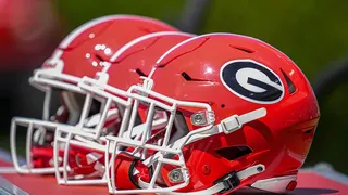 Georgia Bulldogs helmets resting on a bench at Sanford Stadium