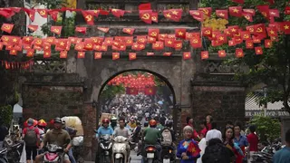 2025年9月1日，越南河內，一群機車騎士穿過舊城區的城門。（美聯社）