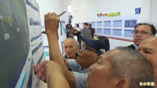 「我的地也在徵收範圍嗎？」老農拿手機拍河川治理範圍，焦急心情寫在臉上。(記者花孟璟攝)