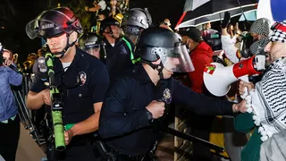 Police officers reacting while anti-Israel students stand their ground at UCLA campus