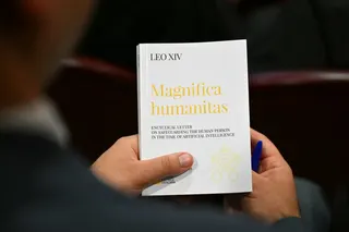 罗马天主教教宗良十四世周一颁布了题为《伟大的人类》的通谕，一位人士手中拿著这份通谕。教宗从道德角度把人工智能(AI)恐将带来日渐严重的冲击比喻为《圣经》里的“巴别塔”。他表示，人工智能恐将让“反人类的威胁正常化”。（图取自法新社）