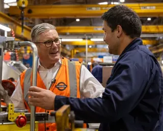 Keir Starmer smiles as he talks with an apprentice