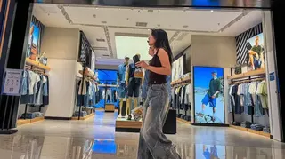 兩個女性走過一家男裝店舖（資料圖片）