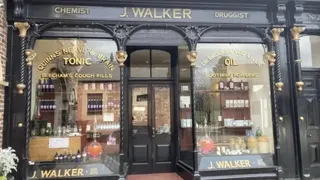 綠金色相間的店面，上面寫著「J Walker」、「化學家」和「藥劑師」