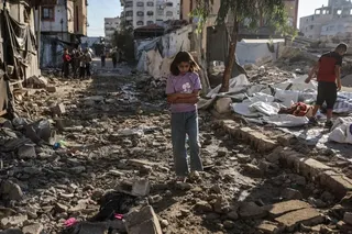 A Palestinian girl walks through the site of an overnight Israeli military strike on structures and tents housing displaced families in Gaza City