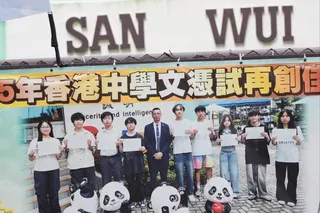 A banner is displayed featuring principal Lee Cheuk-hing with students of San Wui Commercial Society Secondary School. Photo: Jelly Tse