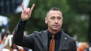 Head coach Steve Sarkisian holding Horns Up gesture walking into stadium