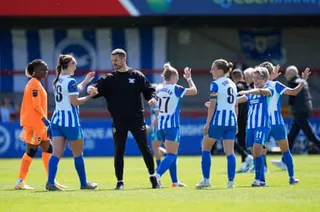 Brighton head coach Dario Vidosic high-fives his players after the Women’s Super League match against Manchester City