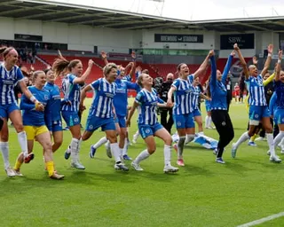 Brighton players hold hands and raise their arms in celebration after victory during the Women's FA Cup semi-final match against Liverpool