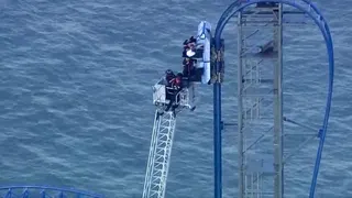 Firefighters used a ladder truck and safety harnesses to rescue passengers one by one from the stalled roller coaster.