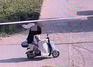 一對男女將「鋤頭」藏擋風布下騎車離開。（圖／翻攝大河報）