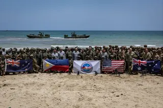 Troops from New Zealand, the Philippines, Australia and the US pose with their national flags after taking part in the Balikatan drills in the Philippines last month. Photo: Reuters