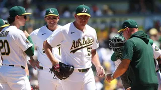 Athletics pitcher Jacob Lopez handing ball to manager Mark Kotsay during baseball game