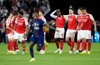 Arsenal players watch on as PSG begin to celebrate their Champions League victory