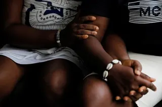 Two seated women hold hands