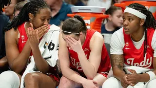 Aliyah Boston talking to Caitlin Clark on the bench during a basketball game