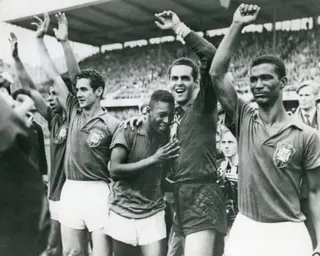 Brazil football players celebrate with arms raised while Pelé embraces goalkeeper Gilmar