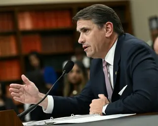 A middle-aged man speaks into a mic