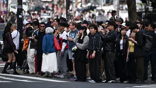 People waiting to cross Shibuya Crossing in Tokyo during a busy holiday period