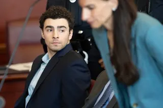 a man sits at a table in a courtroom