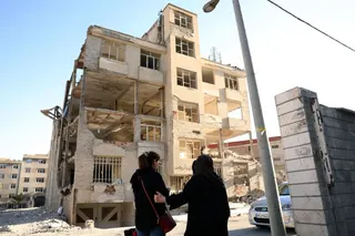 epa13011956 Iranian women walk in front of a residential building, destroyed by previous US-Israeli airstrikes, in Tehran, Iran, 02 June 2026. The Iranian Foreign Minister stated that the agreement between Iran and the US is 'a ceasefire on all fronts, including in Lebanon,' warning that its breach on one front constitutes a 'violation of the ceasefire on all fronts.' EPA/ABEDIN TAHERKENAREH RESTRICTIONS: NO Access Israel Media/Persian Language TV Stations Outside Iran/Strictly No Access BBC Per