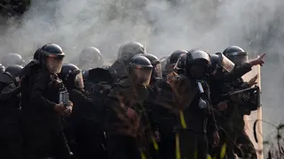 Police officers firing tear gas at community members at Humberto Suarez oil facility in Bolivia