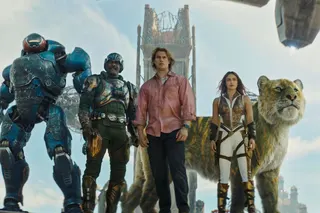 A couple of people standing together alongside a robot and a tiger