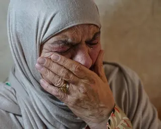 Feryal Abu Haikal, the grandmother of seven month old Palestinian boy, looking very distraught holding her hand up to her face.