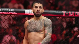 Ilia Topuria wearing red gloves facing Charles Oliveira wearing blue gloves in UFC fight