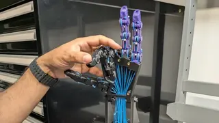 一隻人手在工作台上操作一隻機械手