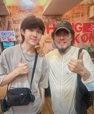 高齡73歲的張菲（右）依舊維持著招牌的墨鏡與落腮鬍造型，面對鄺澤東的合照要求展現十足親和力。左為《超級紅人榜》最新的衛冕冠軍鄺澤東。（翻攝自臉書）