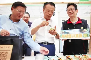 嘉義縣長翁章梁(中)與雲嘉南管理處長徐振能(左)品嚐布袋美食。(記者林宜樟攝)