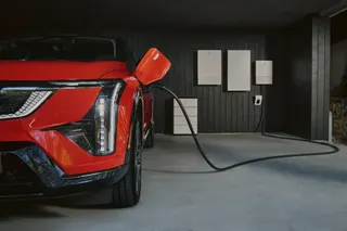 A Cadillac EV in a garage, charging.