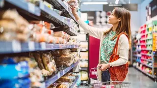一名女子在超市貨架上挑選食品