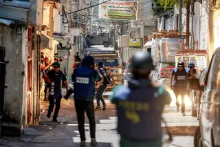 A stun grenade explodes while journalists film as an Israeli army armoured vehicle approaches along an alley in the Balata camp for Palestinian refugees, east of Nablus in the occupied West Bank, during an Israeli military operation on June 7, 2026.