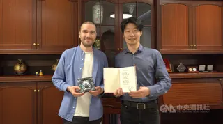 「臺灣漫遊錄」芬蘭文版譯者勞諾（左）拜訪駐芬蘭代表林昶佐（右），雙方分別展示林昶佐回贈的閃靈樂團CD以及帶有楊双子簽名的芬蘭文譯本，身為文化人惺惺相惜。中央社記者巫祈麟赫爾辛基攝　115年6月11日
